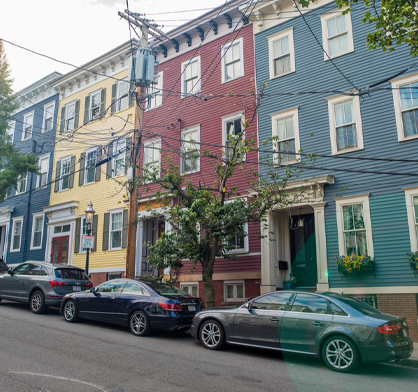 Row homes with cars parallel parked outsided